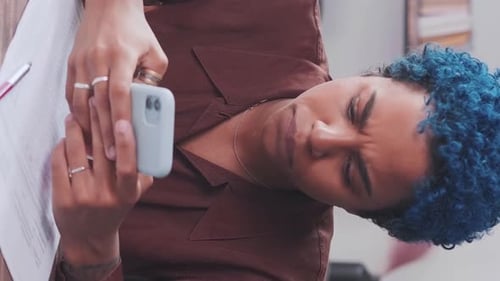 Young Joy African American Woman Entrepreneur Uses Phone Sits in Office at Table