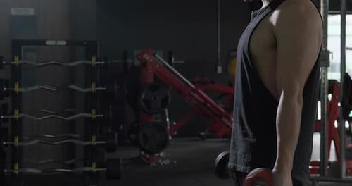 Sportsman doing warm up by stretching arms before exercises at the gym.