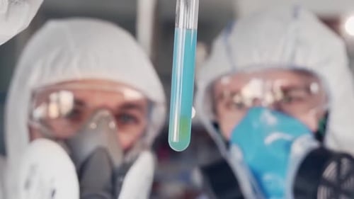 Scientists in Hazmat Suits Examine Test Tube