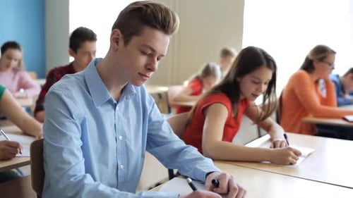 Teenage Students Studying and Writing in a Classroom