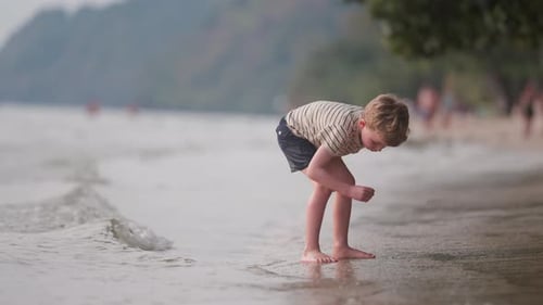 Boy Playing on Sandy Beach Shoreline