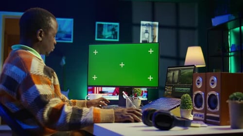 Videographer Creating Visual Effects on Montage Next to Green Screen