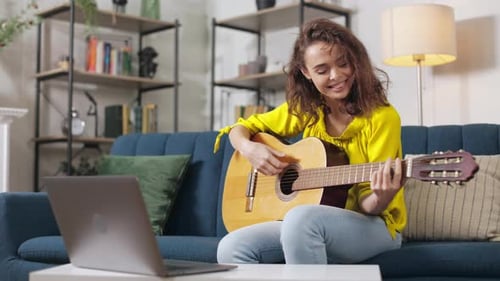Woman Plays Guitar and Sings at Home