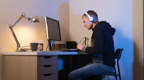 Young Adult Working at Computer at Home at Night