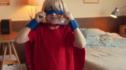 Boy Puts on Mask in Bedroom and Gives Thumbs-Up