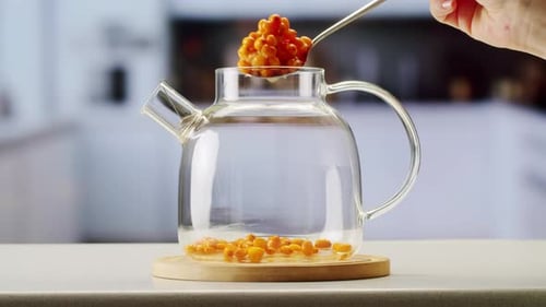 Argousier, baies saines pour le thé, boisson, baies mûres surgelées dans un bocal en verre et branches avec