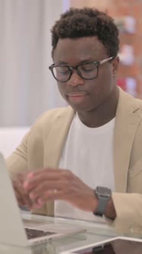Man Working at Laptop in Modern Workspace Smiling