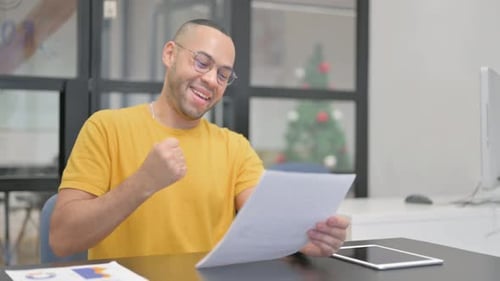 Excited Man Celebrates Success at Office Desk