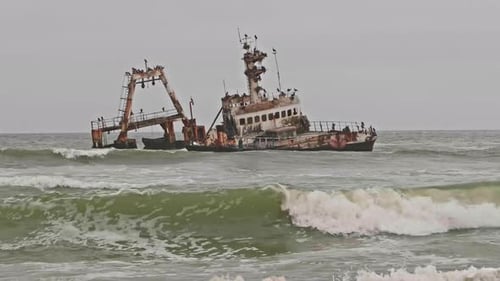 Waves rolling in past Zeila shipwreck along Namibia Skeleton Coast, Wide Shot