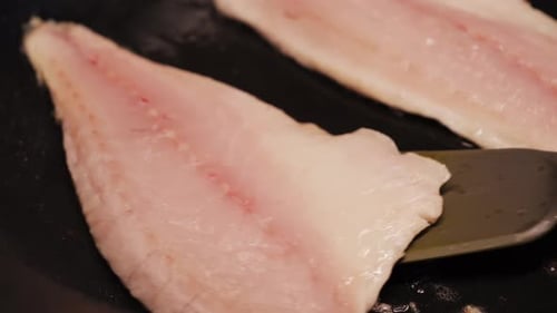 Delicious Fish Fillets Sizzle in Hot Frying Pan