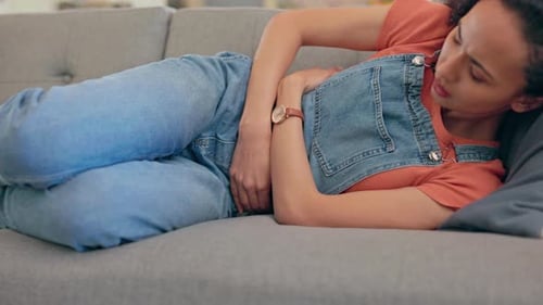 Woman With Abdominal Pain Lying on Couch