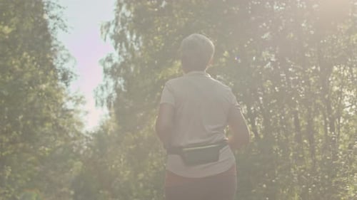 Senior Woman Jogging Outdoors Back View