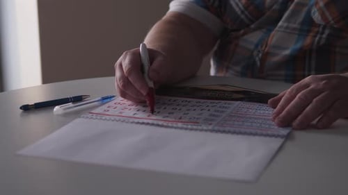 Hands marking dates on a calendar at home