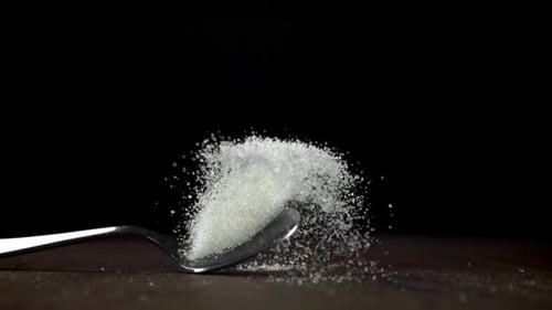 A Spoonful of Sugar Falls on the Table Filmed on a Highspeed Camera at 1000 Fps