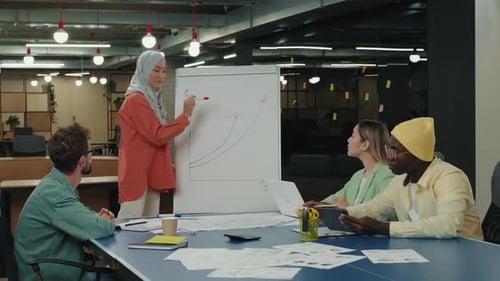 Diverse Team Analyzes Graph in Modern Office