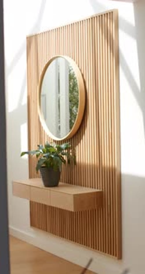Vertical video: Camera pulling back, door opening, revealing wood slat wall with mirror and planter