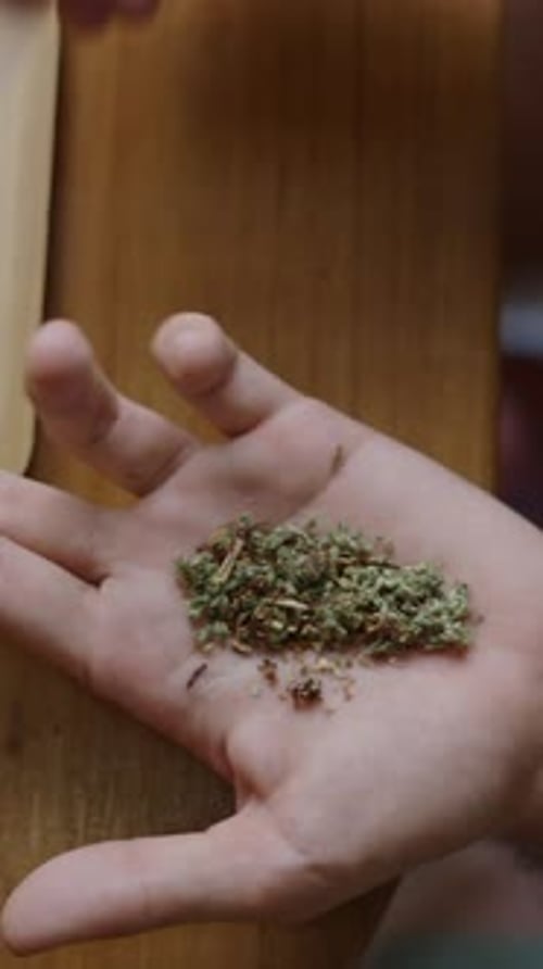 A Man Hands Preparing a Joint of Grass