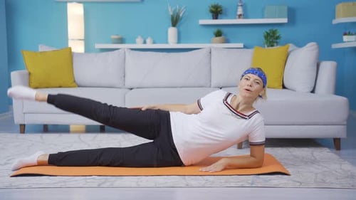 Woman Doing Leg Lifts Indoors on Yoga Mat