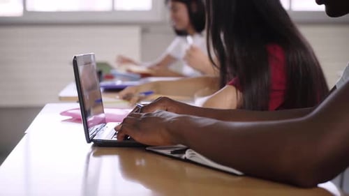 Plan rapproché des mains d'un garçon tapant sur un ordinateur portable dans Classroom Generation Z et Study Academies Copy Space