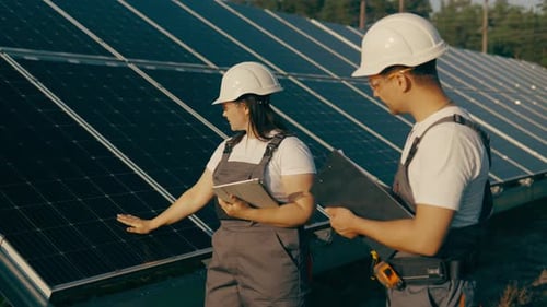 Two Engineers Walk Around Checking the Functionality of a Solar Farm