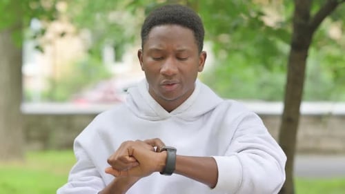 African Man Using Smart watch in a Park