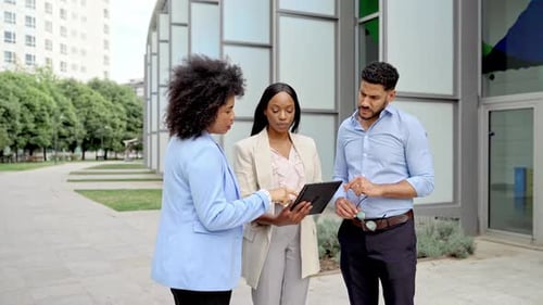 Business Professionals Discussing a Tablet Outside an Office Building