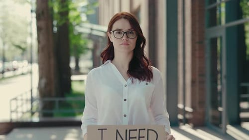 Portrait of Ginger Businesswoman Wearing Glasses Holding Poster Cardboard with Need Job Jobless