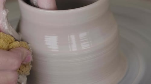 Un potier fabriquant une tasse sur un tour de potier.