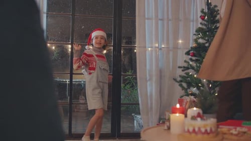 Family Watching Snowfall by Window on Christmas