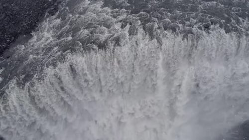 Aerial tilt down view over Dettifoss waterfall in Iceland's winter landscape