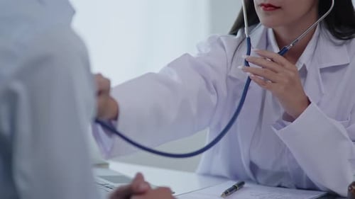 Doctor Examining Patient With Stethoscope In Office