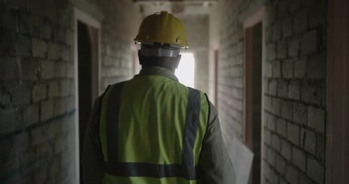 4k video footage of a man walking down a passage of a building at a construction site