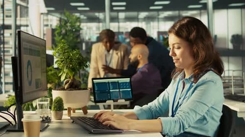 Employee at Office Desk Typing on Keyboard Editing Documents on Computer