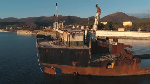 Abandoned Shipwreck Rusting Near the Coast in Calm Waters