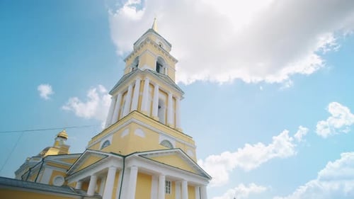 Picturesque view of Orthodox church with a tall yellow and white tower