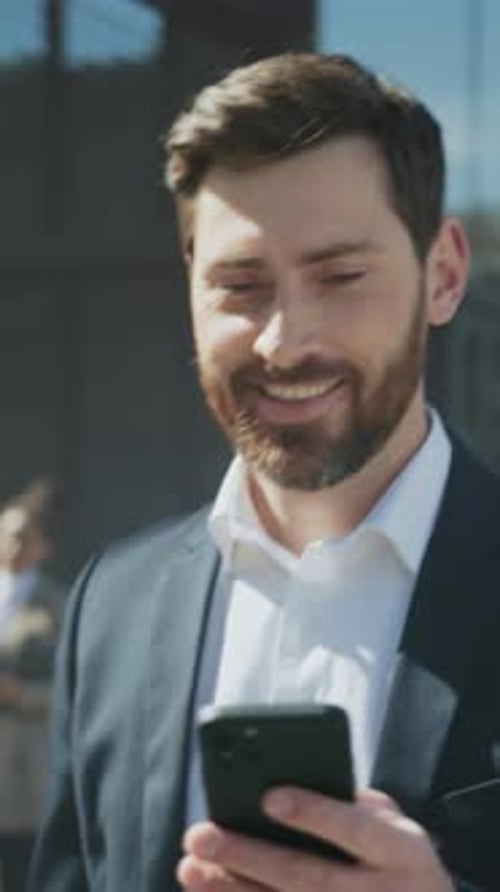 Man in Suit Checks Messages Outside Building Urban Professional Engaging with Smartphone Under