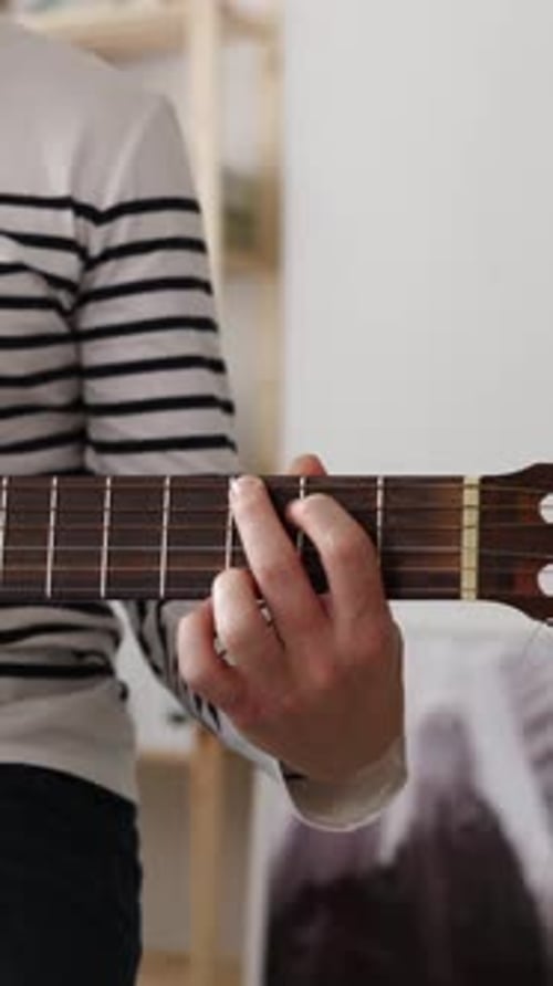 Closeup View of Young Man Playing the Guitar at Home