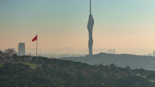Cityscape View With Communication Tower and Waving Flag