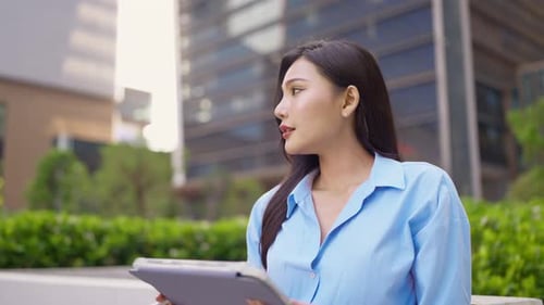 Asian young beautiful businesswoman working outdoors in the modern city.