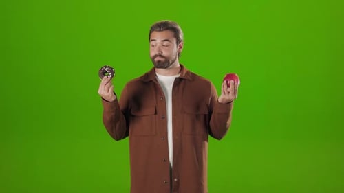 Hombre eligiendo entre manzana fresca y rosquilla dulce