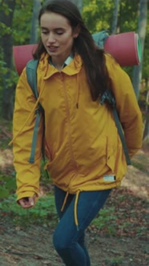 Young Woman with Backpack Exploring Woodland Trail Girl in Yellow Jacket Trekking Through Leafy