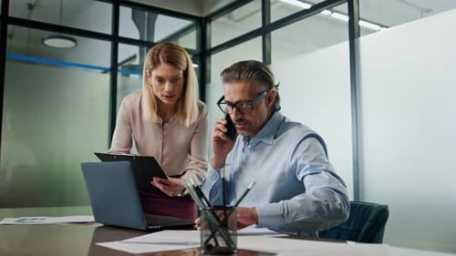 Two Employees Working Together in Office