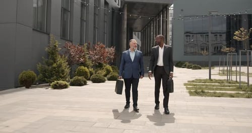 Business People Walking Outdoors Near Office Building