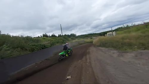 Motorcyclist Rides Dirt Bike on Rural Winding Track