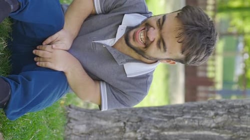 Vertical Video of The dwarf young man laughing to himself in the park is insane.