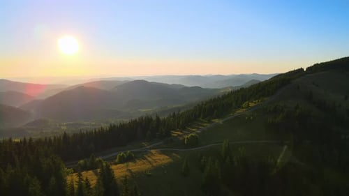Bela paisagem natural, vista aérea do pôr do sol colorido em Wild Mountains Dark Dirt Road