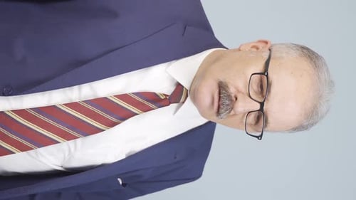 Vertikales Video eines alten Geschäftsmannes, der Nein zur Kamera sagt.
