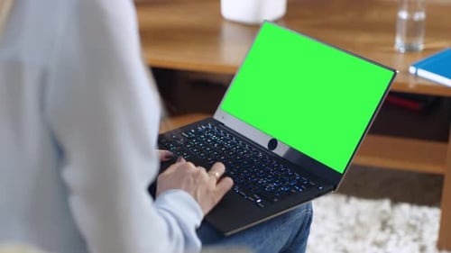 Over the Shoulder Shot of a Woman Holding Green Screen Mock-up Laptop on Her Lap.