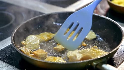 Fried chicken chops on hot frying pan. Cooking meat in restaurant.