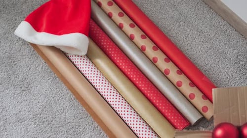 Christmas Wrapping Paper and Ornaments on Gray Carpet